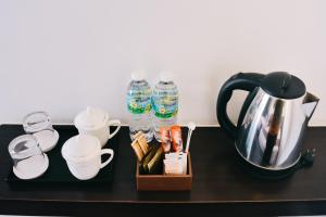 瓜拉丁加奴J套房酒店的茶壶、杯子和饮料的桌子