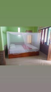 HitokalakLena house Flores的一间卧室,配有一张带蚊帐的床