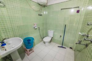 RinchingpongYangsum Heritage Farm的绿色瓷砖浴室设有卫生间和水槽