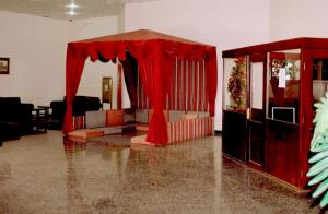 IbrāOYO 142 Al Sharqiya Sands Hotel的客厅配有红色窗帘和沙发