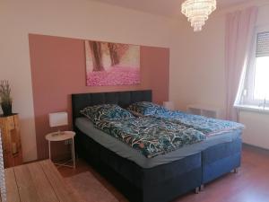 比特费尔德Ferienwohnung am Keramikatelier的卧室配有一张蓝色的床,墙上挂着一幅画