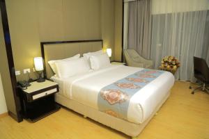 亚的斯亚贝巴Check Inn Hotel Addis Ababa的酒店客房设有一张大床和一张书桌。