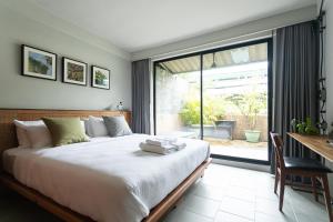 曼谷GalileOasis Boutique Hotel的一间卧室配有一张床、一张书桌和一个窗户。