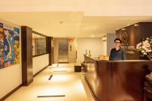 河内Bay Luxury Hotel - No 9 Nguyen Truong To, Ba Dinh, Ha Noi的站在酒店大堂柜台的女人