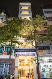 河内Bay Luxury Hotel - No 9 Nguyen Truong To, Ba Dinh, Ha Noi的建筑前有树木的商店