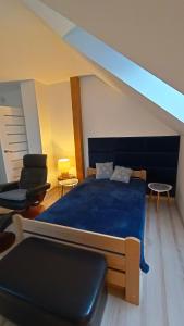SzałszaKomfortowe Noclegi的一间卧室配有蓝色的床和椅子