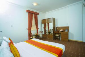 多哈拉维拉酒店的酒店客房带一张床、一张桌子和椅子