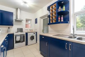 赫尔J's Home Away From Home FrEsH 2 Bedroom Garden Parking的蓝色的厨房设有水槽和洗衣机
