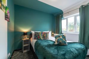 赫尔J's Home Away From Home FrEsH 2 Bedroom Garden Parking的蓝色的卧室设有床和窗户