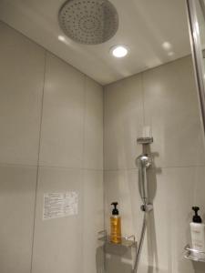 广岛Smile Hotel Hiroshima的带淋浴喷头的浴室