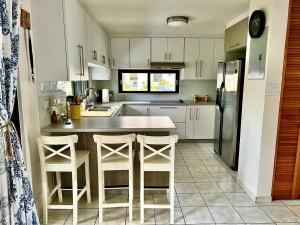 里奥格兰德Entire Beach Apartment with view to El Yunque National Rain Forest的厨房配有白色橱柜、桌子和凳子