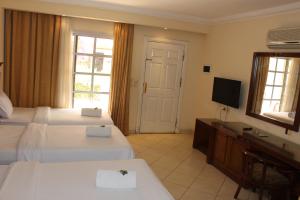 沙姆沙伊赫Herrmes Hospitality的酒店客房设有两张床和电视。
