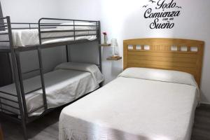 加的斯Apartamento “Las Cuadras “的卧室配有两张双层床,并设有一个阅读俱乐部夏季的标志。