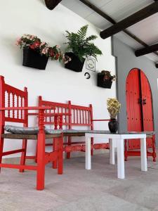 加的斯Apartamento “Las Cuadras “的一间设有两个长凳和一张桌子的房间,配有盆栽植物