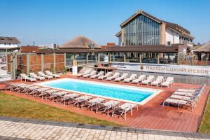 茹里洛夫卡Razelm Luxury Resort的一座带躺椅的游泳池和一座建筑