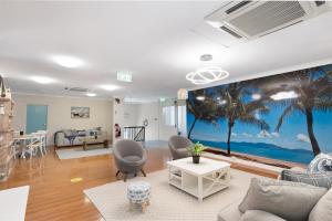 汤斯维尔Seaside Lodge Townsville的一间拥有棕榈树壁画的客厅