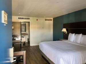 瓦列霍Studio 6 Vallejo CA Napa Valley的酒店客房设有一张大床和一个厨房。