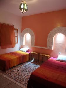 Rhorm el AlemLe jardin d'habiba的带2个拱门的客房内的2张床