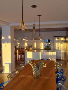 皮拉茹Casa francesa de Piraju的厨房以及带花瓶木桌的用餐室。