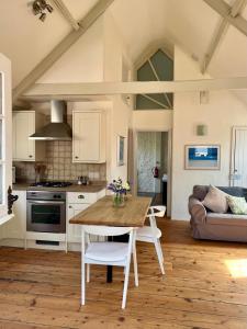 布里德波特Norburton Hall Cottages的厨房以及带木桌的起居室。