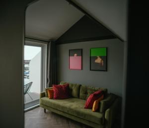 布莱顿霍夫Tiny Floating Home with Marina Views的客厅设有绿色沙发和窗户。