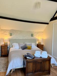 布里德波特Norburton Hall Cottages的一间卧室配有一张大床和毛巾