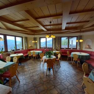斯拉德明Hotel Pension Berghof的餐厅设有桌椅和窗户。