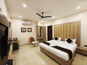 SatnaRadha Residency的一间卧室配有一张大床和电视