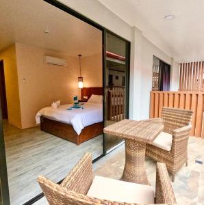 长滩岛Island Princess Resort & Spa Boracay的配有一张床和一张桌子及椅子的房间