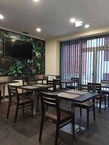 丰沙尔São Francisco Accommodation的用餐室配有桌椅和平面电视。