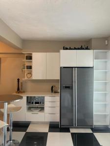 开普敦Home Suite Hout Bay的厨房配有白色橱柜和不锈钢冰箱