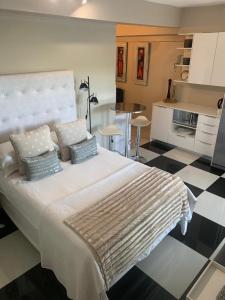 开普敦Home Suite Hout Bay的一间卧室配有一张带枕头的大床,厨房