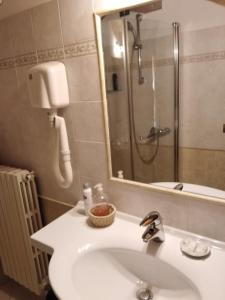 瓦伦纳Villa Torretta的浴室配有盥洗盆和带镜子的淋浴