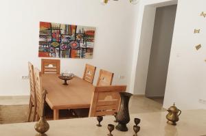 突尼斯Maison plain-pied avec piscine chauffée的一间设有桌子和墙上绘画的用餐室