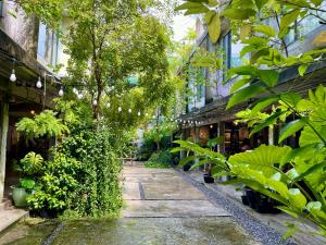 曼谷GalileOasis Boutique Hotel的植物建筑中间的走道
