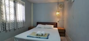 琅勃拉邦Khonesavane Hostel的一间卧室配有一张床,上面有两条毛巾