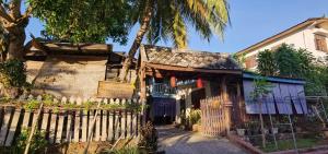琅勃拉邦Khonesavane Hostel的一座前方有栅栏的老房子