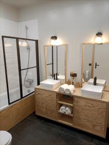 蒙特里夏尔Gite La Gazo - Grande maison chaleureuse.的一间带两个盥洗盆和淋浴的浴室