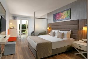 锡德Seven Seas Hotel Blue - Ultra All Inclusive & Kids Concept的酒店客房设有一张大床和一张书桌。