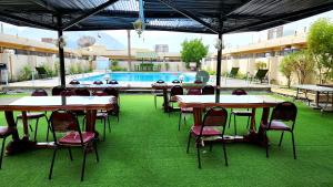 海塞卜海塞卜酒店的一个带桌椅的户外庭院和一个游泳池