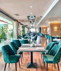 地拉那地拉那国际酒店及会议中心的一间设有绿色椅子和桌子的餐厅