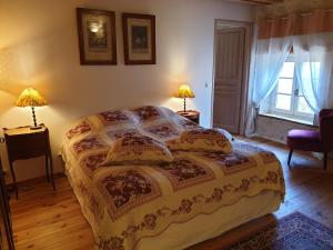 Frontenay-Rohan-RohanLes Écuries的一间卧室配有一张带两盏灯的床和一扇窗户。