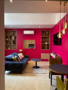 欧坦Suite avec Spa Quartier Cathédrale的带沙发和粉红色墙壁的客厅