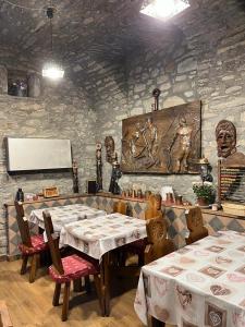 雷梅斯-诺特雷-达梅阿特米西亚旅馆的一间设有两张桌子和石墙的用餐室