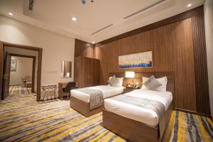 巴勒如拉斯DiYar Home Hotel的酒店客房配有两张床和一张书桌