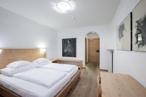 圣洛伦佐-迪塞巴托Rooms Kronblick的卧室配有一张白色的大床和一张桌子