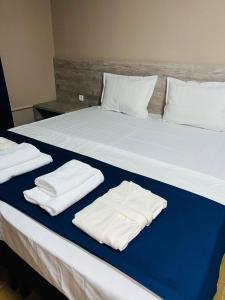 奇姆肯特MINI HOTEL COMFORT的一张大床,上面有白色毛巾