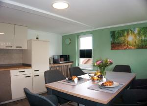 巴特萨克萨Ferienwohnung Ravensberg Dachgeschoss的一间带木桌和椅子的厨房以及一间用餐室