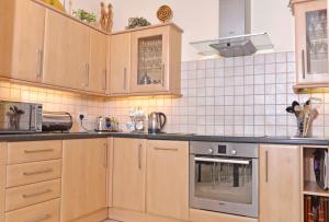 伊斯特布恩Cavendish apartment - central and spacious的厨房配有木制橱柜和不锈钢用具