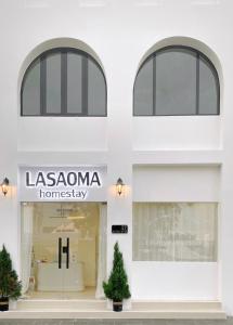 芹苴LASAOMA HOMESTAY的白色建筑前方的商店,具有乳突瘤同质性